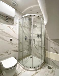La salle de bains est pourvue de toilettes et d'une douche en verre. dans l'établissement Re Ferdinando Apartment, à Naples