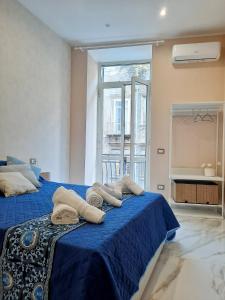 - une chambre avec un lit bleu et des serviettes dans l'établissement Re Ferdinando Apartment, à Naples
