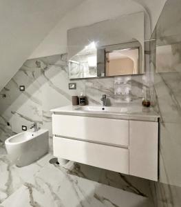 La salle de bains blanche est pourvue d'un lavabo et d'un miroir. dans l'établissement Re Ferdinando Apartment, à Naples
