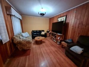 a living room with a couch and a tv at Habitación con baño privado A in Villarrica