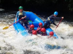 un grupo de personas en una balsa en el agua en Rhydydefaid Cwt Clyd - Cosy Hut, en Bala