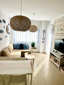 a living room with a couch and a tv at Alicante Hills Apartment Blue in Alicante