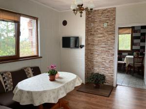 a living room with a table and a brick wall at Къща за гости Ягода in Sapareva Banya