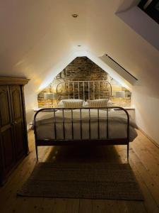 a bed in a room with a brick wall at Historic Cottage in the Heart of Old Aberdeen. in Aberdeen
