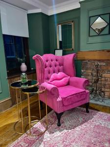 un divano rosa in un soggiorno con tavolo di Historic Cottage in the Heart of Old Aberdeen. ad Aberdeen Altre 7 foto