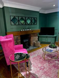 sala de estar con sillas rosas y chimenea en Historic Cottage in the Heart of Old Aberdeen. en Aberdeen
