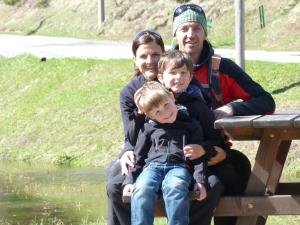 una famiglia seduta su una panchina vicino a un fiume di Bio & Reiterhof der Veitenhof a Niederthai