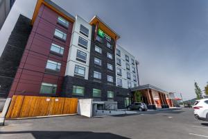 a large building with a fence in a parking lot at Holiday Inn Express & Suites - Chilliwack East an IHG Hotel in Chilliwack