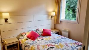 sypialnia z łóżkiem z 2 różowymi poduszkami w obiekcie Gîte Bulle de détente-Aux Portes d'Honfleur avec piscine couverte w mieście Boulleville +10 zdjęć