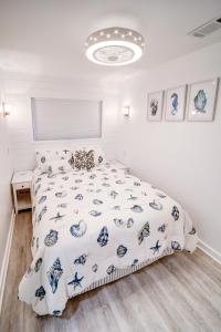 Schlafzimmer mit einem Bett mit einer blauen und weißen Bettdecke in der Unterkunft Palm Paradise in Isle of Palms