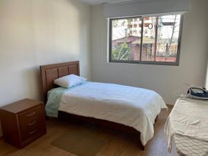 a bedroom with two beds and a window at Deluxe Department in Cochabamba