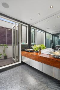 a bathroom with two sinks and a large mirror at Central High-end 3BR Home in Parnell with Pool in Auckland