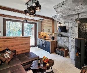 a living room with a couch and a stone fireplace at Pienińska Grota - z Kominkiem i Basenem - przy Wyciągu in Szczawnica