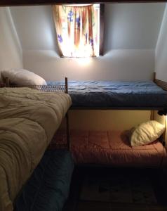 2 łóżka piętrowe w pokoju z oknem w obiekcie Chalet lac de Payolle w mieście Ancizan