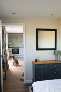 a dog walking in a room with a kitchen at Sweet Pea Cabin in Badsey