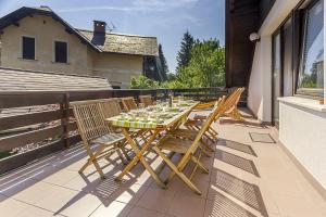 a wooden table and chairs on a balcony at Apartment Harmony Bled in Bled