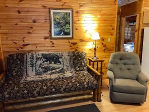 een slaapkamer met een bed en een stoel bij Hominy Ridge Cabins and Gift Shop in Sigel