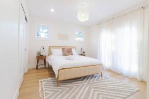 a white bedroom with a bed and a rug at Home in the heart of willow Glen San Jose in San Jose