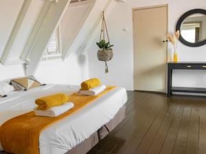 a bedroom with a bed with yellow towels on it at Landhuis Daniel - Plantation House in Tera Kora