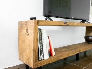a wooden shelf with books and a television on it at Landhuis Daniel - Plantation House in Tera Kora