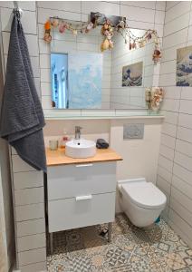 a bathroom with a sink and a toilet and a mirror at La Casa de Koko in Las Palmas de Gran Canaria