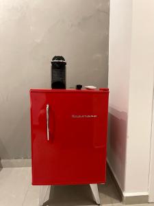 un refrigerador rojo con una bolsa encima. en Acomodações Tio Will, en Guarujá