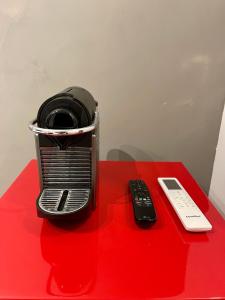 una tostadora y un mando a distancia sentado en una mesa roja en Acomodações Tio Will en Guarujá