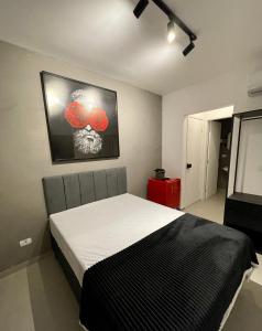 een slaapkamer met een bed en een foto van een schedel bij Acomodações Tio Will in Guarujá