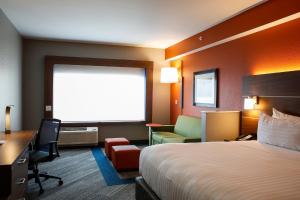 una camera d'albergo con letto, scrivania e finestra di Holiday Inn Express & Suites Downtown Louisville, an IHG Hotel a Louisville