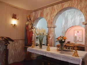 a room with a altar with a statue and a mirror at Villa Sacro Cuore in San Giovanni Rotondo