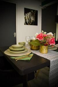 a table with plates and a vase of flowers at 1 Bed Apartment B in Birmingham