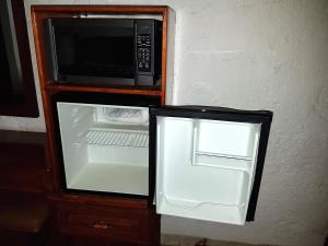 um frigorífico aberto com um micro-ondas no interior em State Inn em Chihuahua