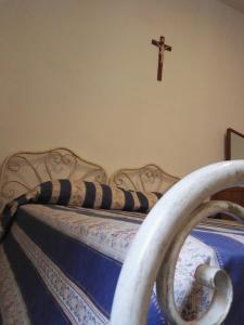 ein Schlafzimmer mit einem Bett mit einem Kreuz an der Wand in der Unterkunft Villa Sacro Cuore in San Giovanni Rotondo
