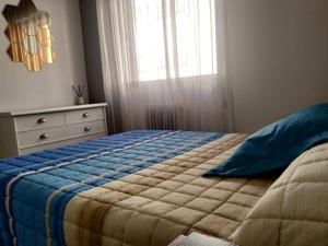 薩莫拉的住宿－Los 3 arboles，一间卧室配有一张带蓝色毯子的床和窗户。