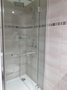 a shower with a glass door in a bathroom at Les Jardins de la quiétude in Bettancourt-la-Ferrée