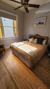 Schlafzimmer mit einem Bett und einem Deckenventilator in der Unterkunft 'Pickett's Cottage' - Circa 1868 - Oldest in Knox! in Boronia