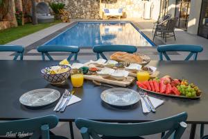 a table with food and fruit next to a pool at סוויטת הרמס- סוויטת פאר עם בריכת שחיה פרטית in Safed
