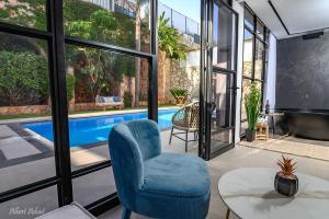 - un salon avec une chaise bleue et une piscine dans l'établissement סוויטת הרמס- סוויטת פאר עם בריכת שחיה פרטית, à Safed
