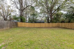 a backyard with a wooden fence and a yard at Adorable Blue Little House in Charleston