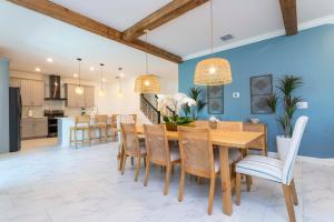 a dining room and kitchen with a wooden table and chairs at Wonderful 8Bd7BA Melbourne Beach w Pool Dock & Beach in Melbourne Beach