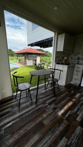 eine Küche mit einem Tisch und 2 Stühlen vor einem Fenster in der Unterkunft Sol y Luna Pedasí in Pedasí Town