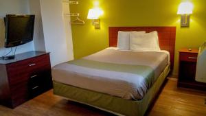 a bedroom with a bed and a flat screen tv at Motel 6-Greensboro, NC - I-40 in Greensboro