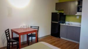 a small kitchen with a table and a refrigerator at Motel 6-Greensboro, NC - I-40 in Greensboro