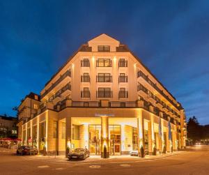 un grande edificio con macchine parcheggiate di fronte di Maison Messmer - ein Mitglied der Hommage Luxury Hotels Collection a Baden-Baden