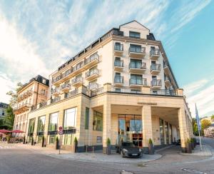 un edificio con un'auto parcheggiata di fronte di Maison Messmer - ein Mitglied der Hommage Luxury Hotels Collection a Baden-Baden