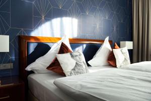 ein Schlafzimmer mit einem Bett und Kissen darauf in der Unterkunft Maison Messmer - ein Mitglied der Hommage Luxury Hotels Collection in Baden-Baden