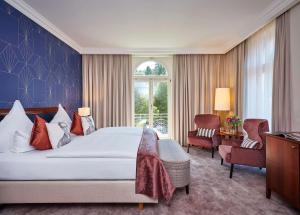 ein Schlafzimmer mit einem großen Bett und einem Fenster in der Unterkunft Maison Messmer - ein Mitglied der Hommage Luxury Hotels Collection in Baden-Baden + 89 Fotos