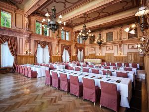 une grande chambre avec des tables et des chaises. dans l'établissement Maison Messmer - ein Mitglied der Hommage Luxury Hotels Collection, à Baden-Baden