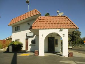 een klein wit gebouw met een rood dak bij Motel 6-Fresno, CA in Fresno