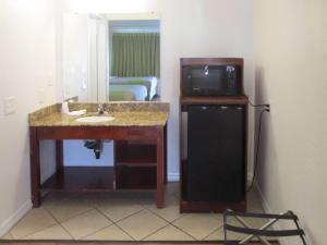 uma casa de banho com um lavatório, um micro-ondas e um frigorífico em Motel 6-Fresno, CA em Fresno